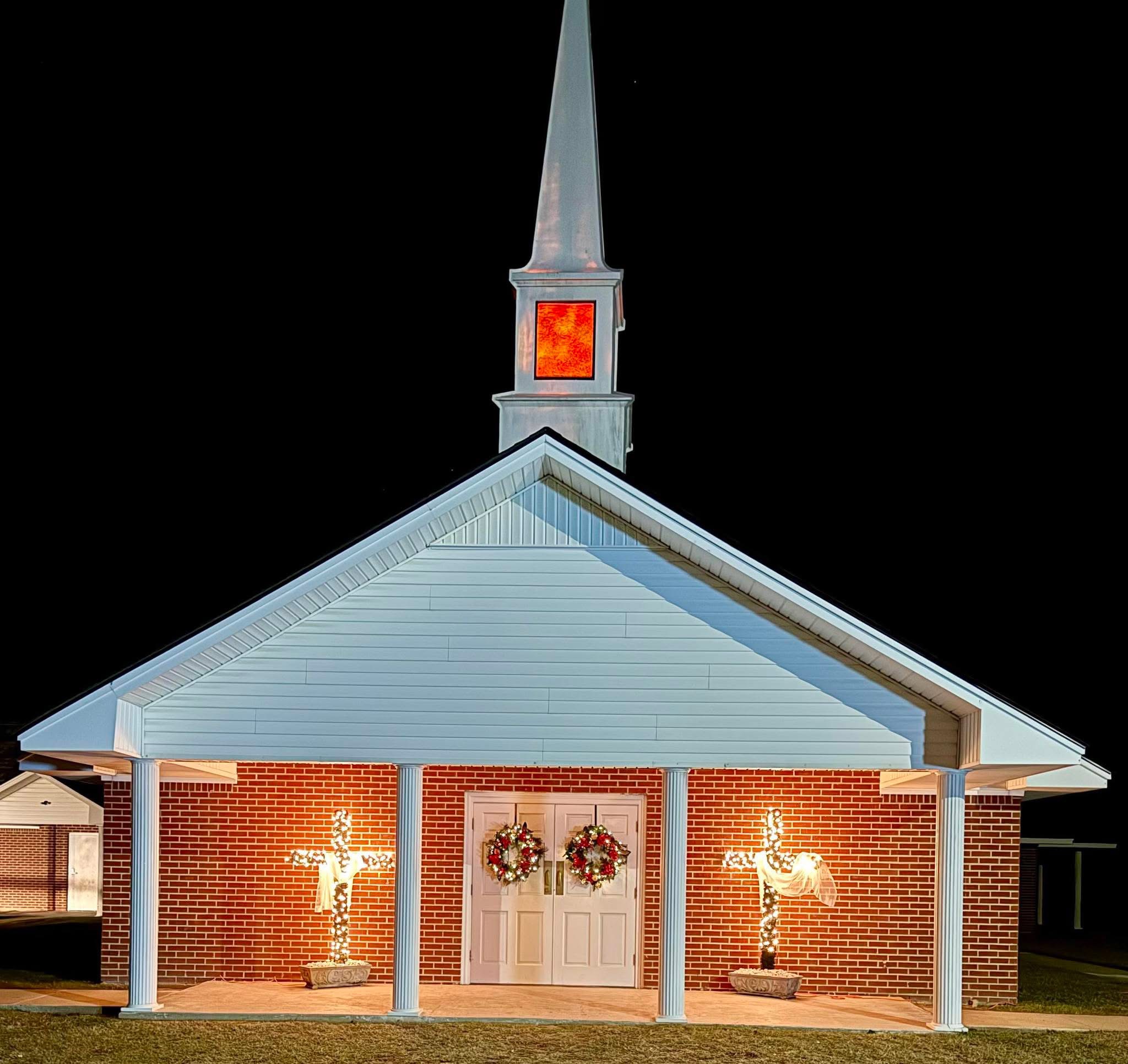 The front entrance and steeple of Zebedee Baptist Church at night